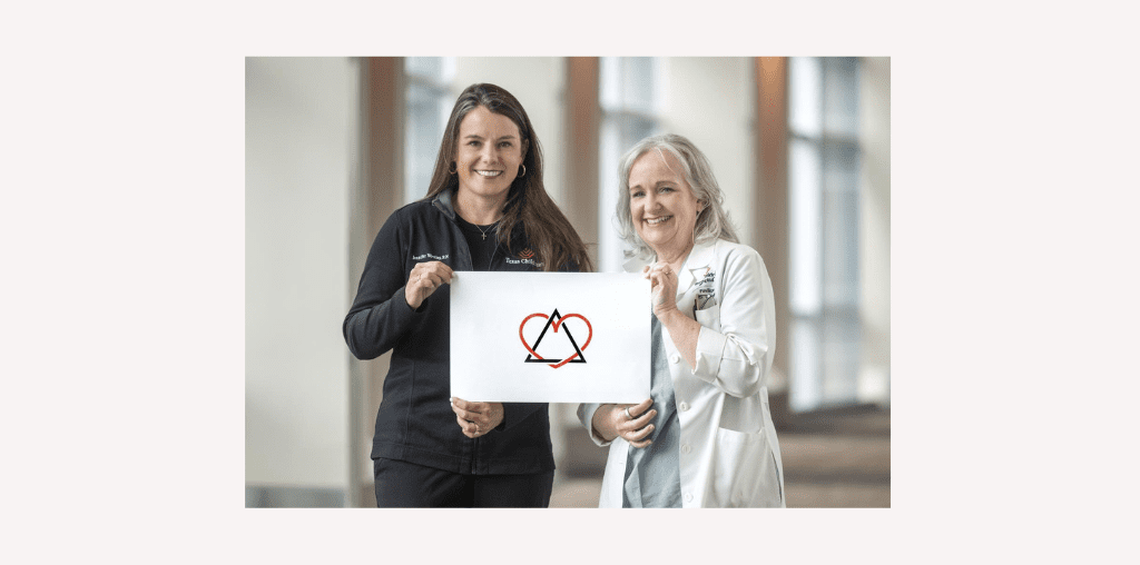 Jennifer and Dr. Bump hold the adoption symbol, a triangle intertwined with a heart, represents the three key figures in the adoption process: the birth family, the adoptive family, and the adoptee. The heart symbolizes the love that connects them all.