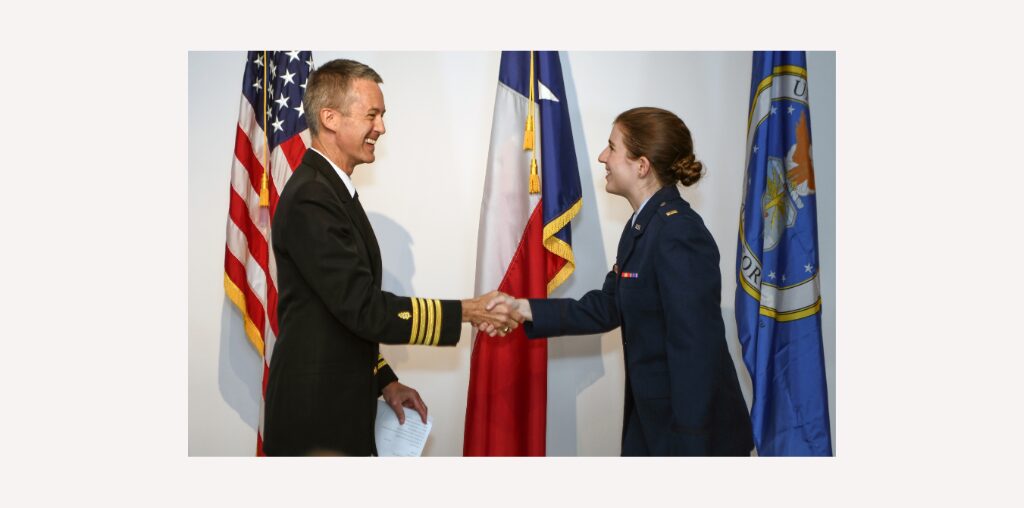 Dr. Tim Porea shakes hand of a female medical student at Baylor College of Medicine military commissioning ceremony.