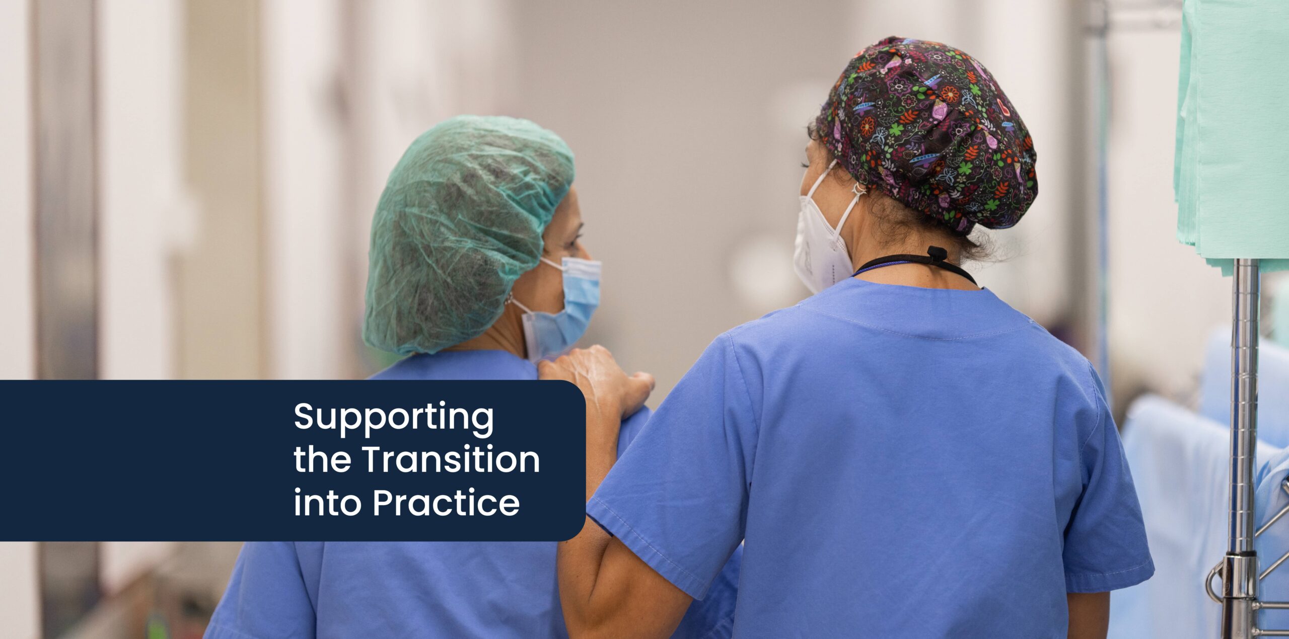 Supporting the Transition into Practice Through Mentorship: A mentor walks with a hand on a nurse resident's shoulder. Both are in scrubs, surgical caps and masks.